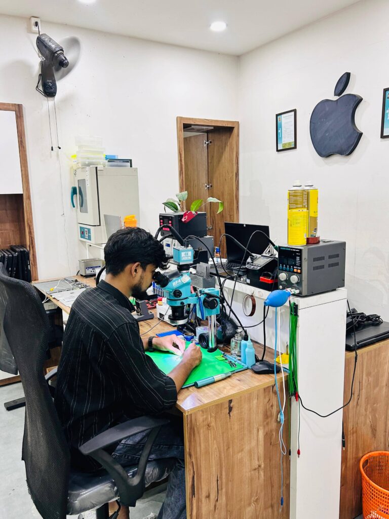image of our technician repairing a phone optimised to show our main branch in erattupetta